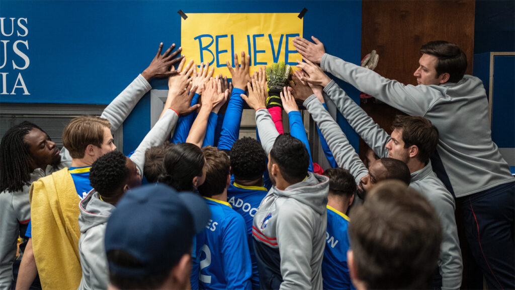 The Richmond AFC team touches the believe poster in Apple's show Ted Lasso. 