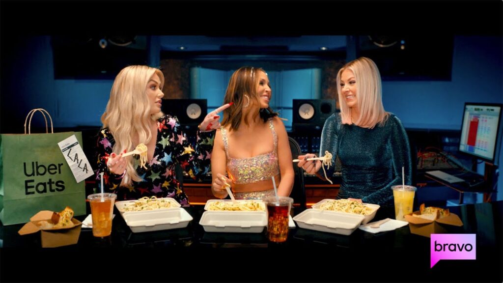 Lala Kent, Scheana and Ariana Madix from Vanderpump Rules are sitting together eating a meal in a recording studio for an Uber Eats promotion after the news of Scandoval. 